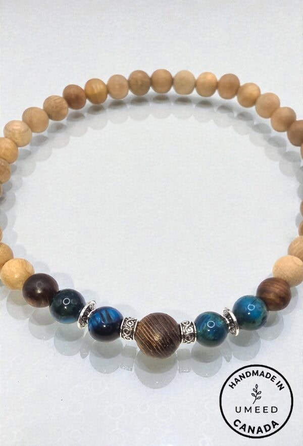 Natural wooden beaded necklace with silver accents and a central dark wood bead, handcrafted in Cana.