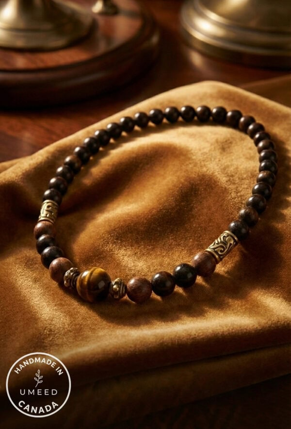 Handcrafted beaded necklace featuring dark wooden beads and gold accents, displayed on a soft velvet.