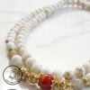 Handcrafted white and gold beaded necklace with a red accent bead, made by Umeed Designs in Canada.
