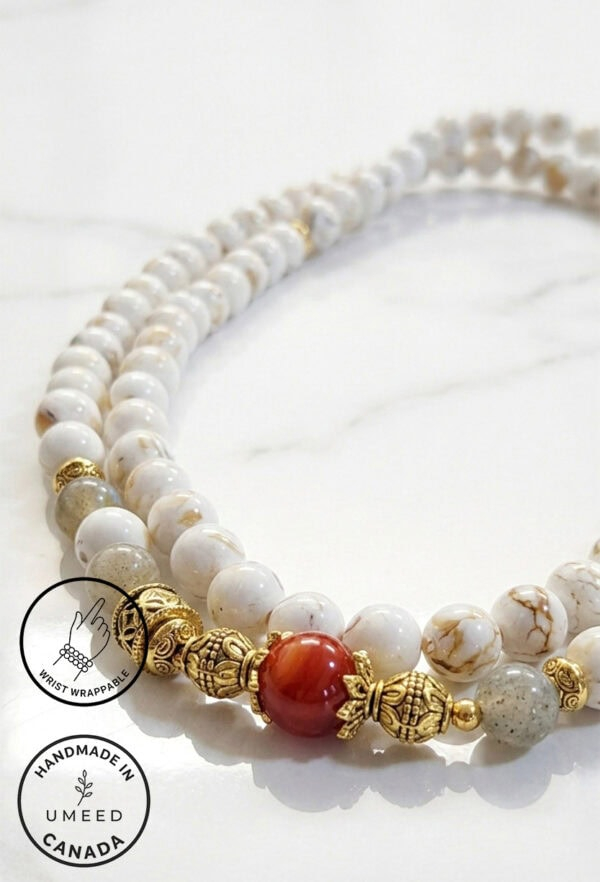 Handcrafted white and gold beaded necklace with a red accent bead, made by Umeed Designs in Canada.