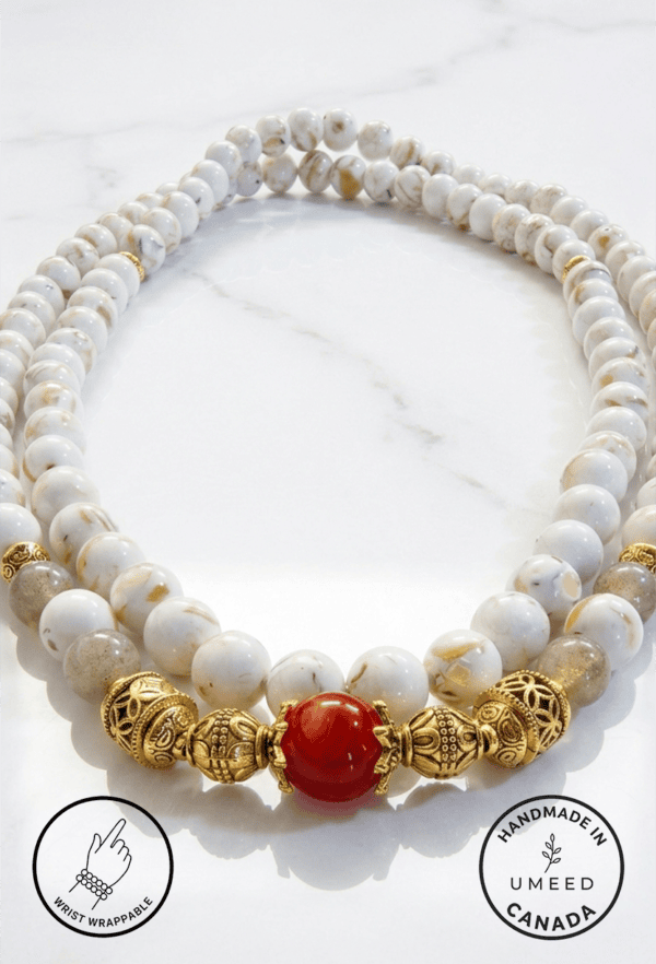 Elegant pearl and gold beaded necklace with a striking red centerpiece. Perfect for sophisticated je.