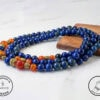 Handmade beaded necklace with vibrant blue and red stones, crafted with care and attention to detail.