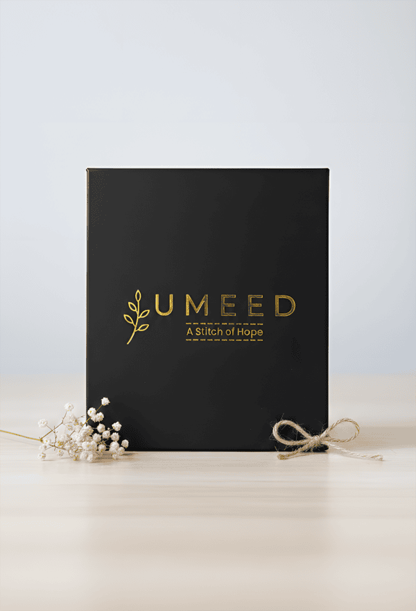 Elegant black gift box with gold logo and natural accents for special occasions.
