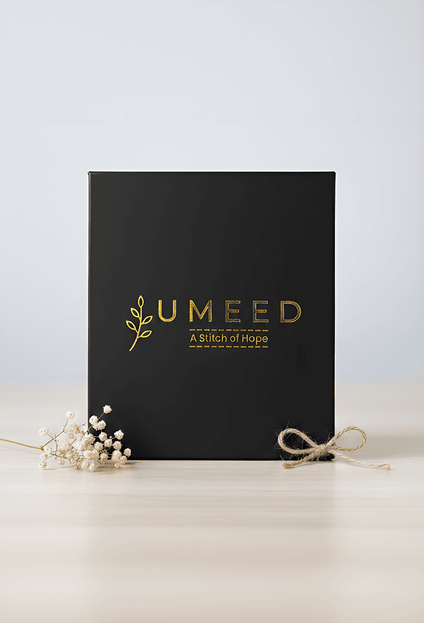 Elegant black gift box with gold logo and natural accents for special occasions.