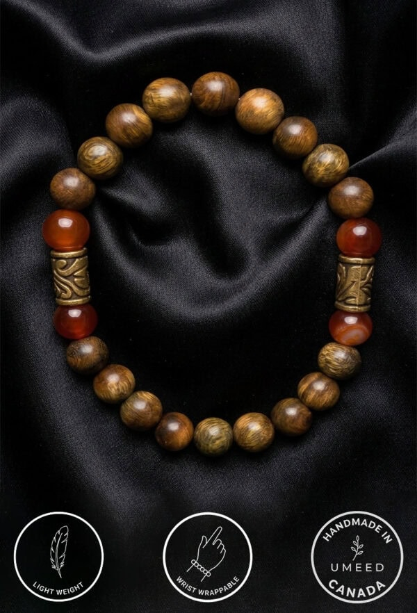 Bracelet featuring natural wooden beads, gold accents, and red stones, displayed on black satin fabr.