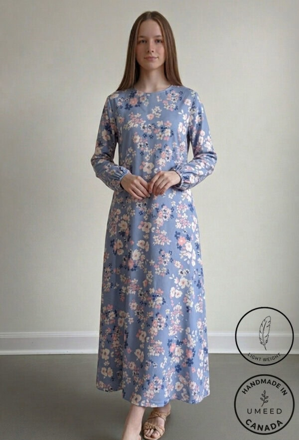Elegant floral maxi dress in soft blue with pink and white flowers, perfect for casual or special oc.