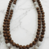 Wooden beaded necklace with white and silver accents.