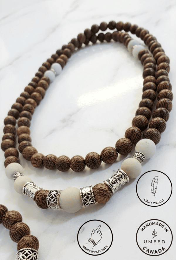 Handmade wooden and white beaded necklace with intricate silver details.