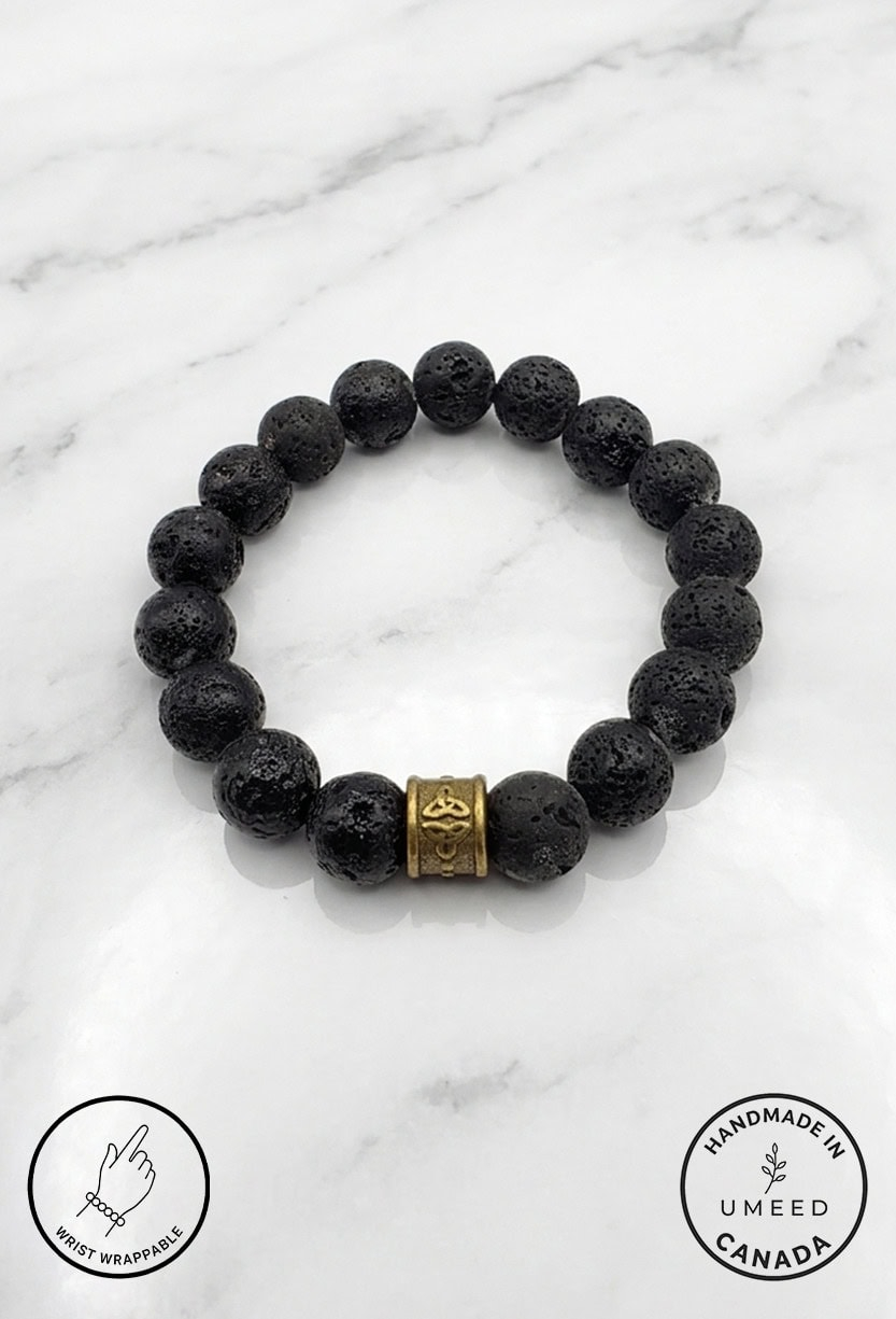 Black lava stone bracelet with a gold decorative bead, handcrafted jewelry from Umeed Designs.