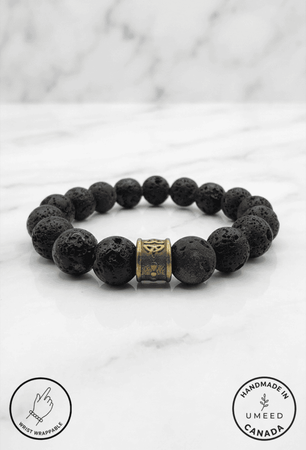 Black lava stone beaded bracelet with a gold charm accent, handcrafted by Umeed Designs.