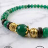 Bracelet featuring green beads, gold charms, and black accents, crafted with care by Umeed Designs i.