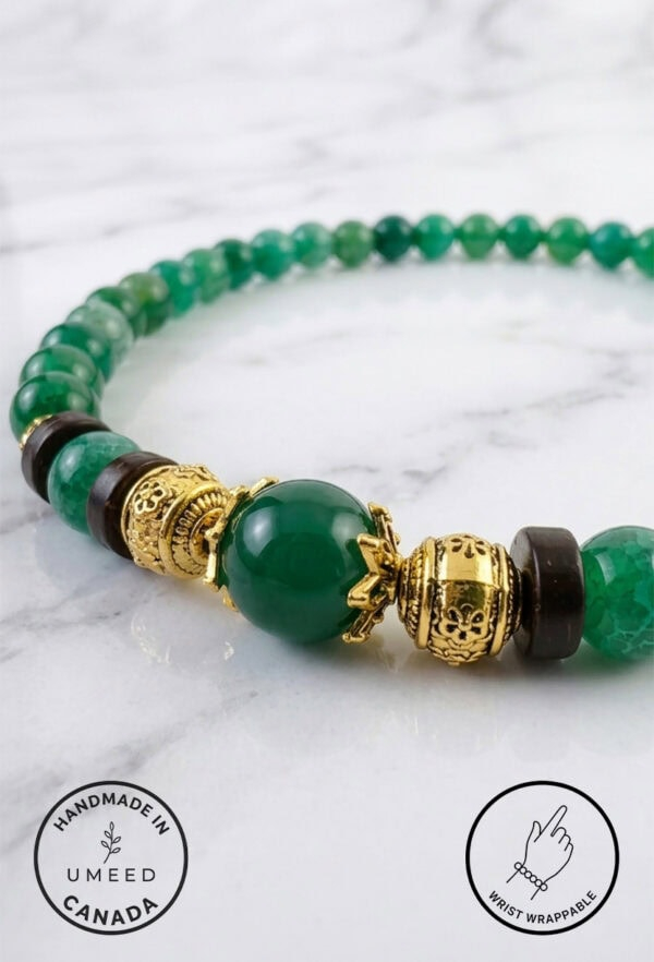 Bracelet featuring green beads, gold charms, and black accents, crafted with care by Umeed Designs i.