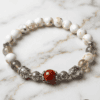Handmade pearl and gemstone beaded bracelet on marble surface.