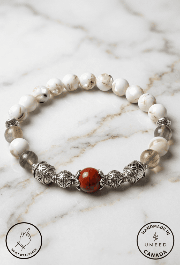 Handmade pearl and gemstone beaded bracelet on marble surface.