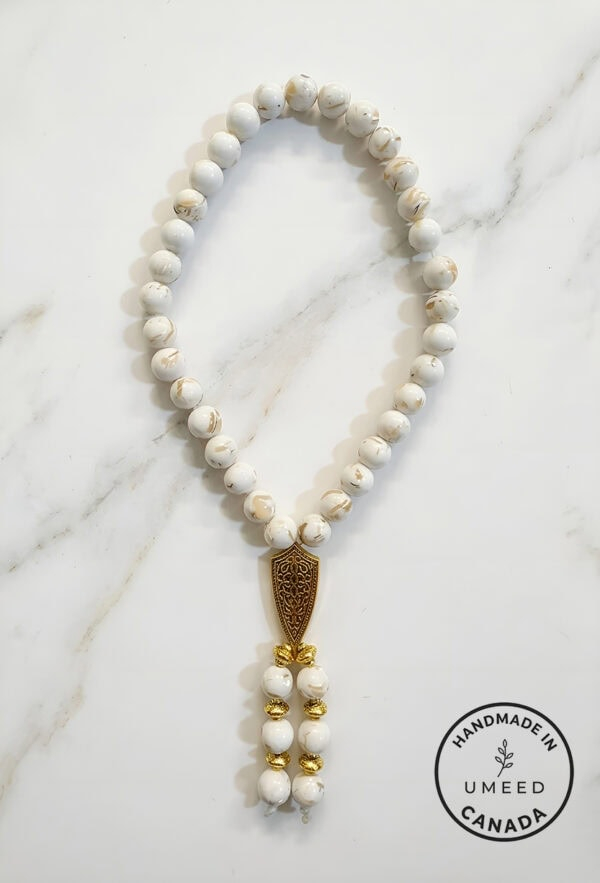 Elegant white beaded necklace with gold accents, handcrafted jewelry from Umeed Designs.