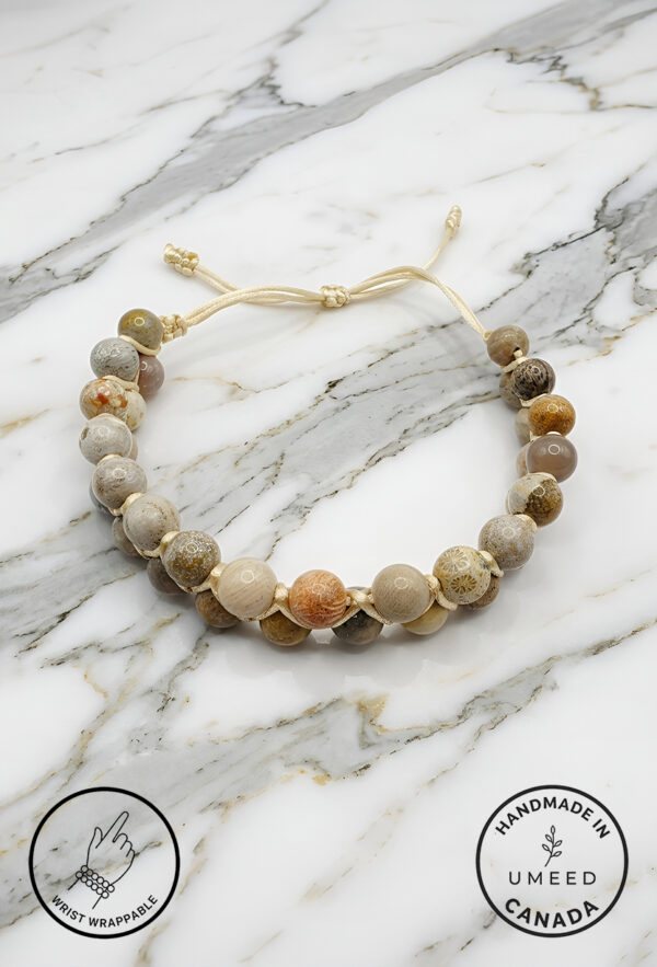 Handmade beaded bracelet with natural stone beads on marble surface.