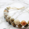Handmade beaded necklace with natural stone beads on marble surface.