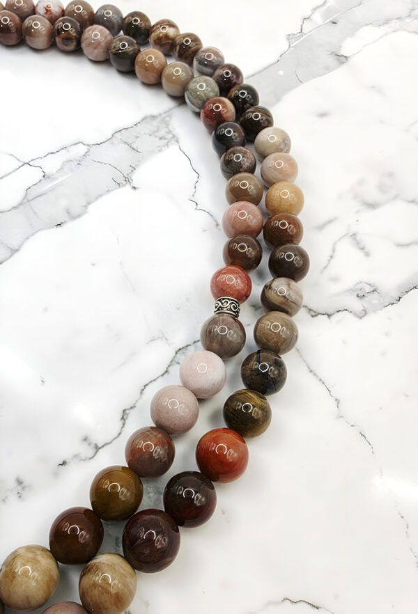 Colorful beaded necklace with round beads on a white marble surface.