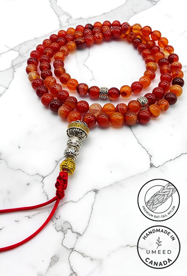 Handmade red and orange beaded mala with silver accents and red tassel.