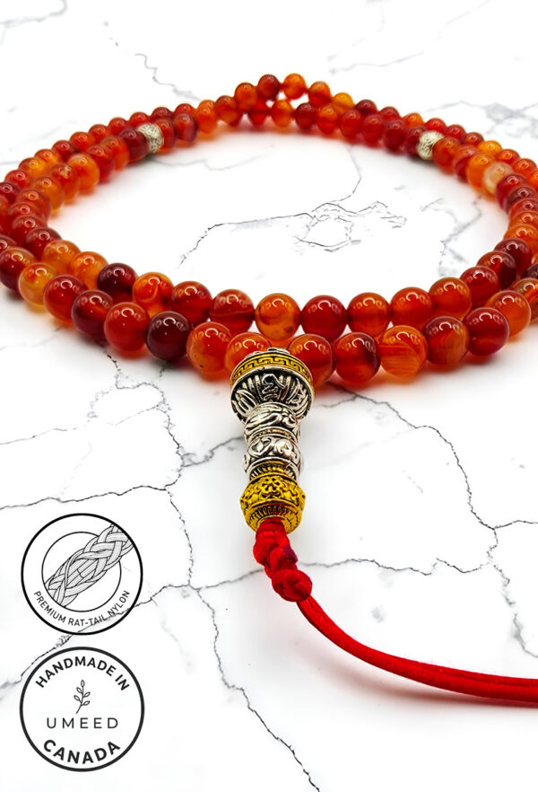 Handmade red and gold beaded mala necklace with decorative silver accents.