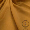 Gold fabric with glitter and light weight texture for fashion or decor.