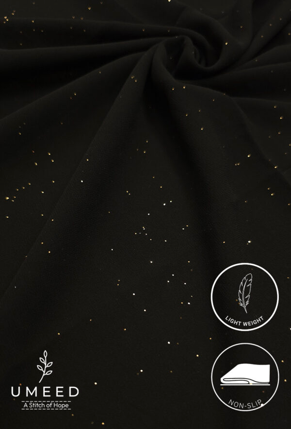 Black fabric with gold specks, lightweight and non-slip for elegant sewing projects.