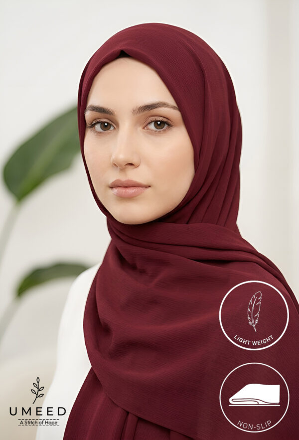 Elegant woman wearing a maroon hijab with a neutral background.