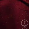 Deep red fabric with gold specks, lightweight and non-slip for elegant clothing.