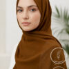 Elegant woman wearing a brown hijab with subtle embellishments for modest fashion.
