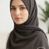 Elegant woman wearing a dark grey hijab with subtle sparkles.