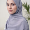 Elegant woman wearing a light gray hijab with subtle embellishments.