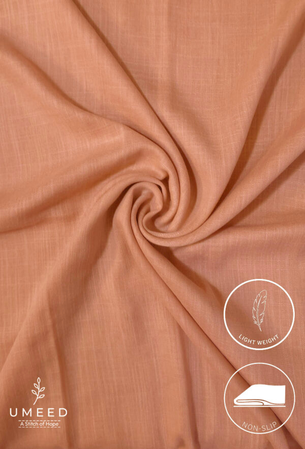 Lightweight, non-slip peach-colored fabric for clothing or crafts.