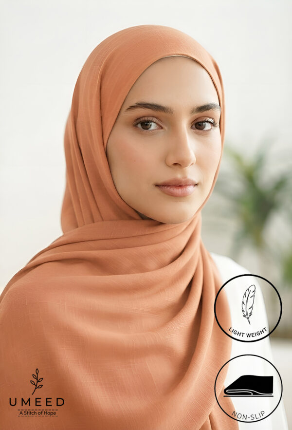 Elegant woman wearing a light weight, non-slip peach-colored hijab.