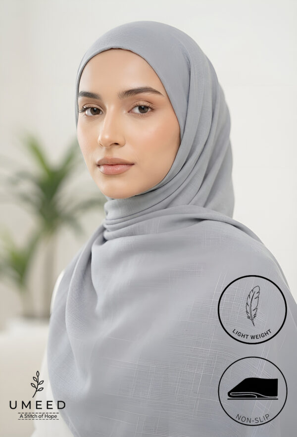 Elegant woman wearing a light gray hijab with a soft background.