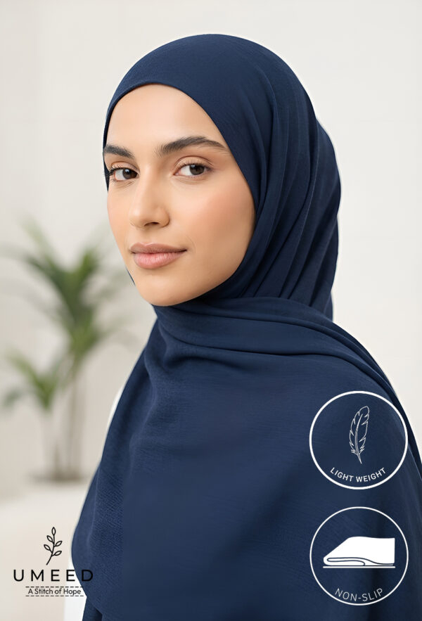 Elegant woman in navy hijab with Umeed Designs logo on clothing.