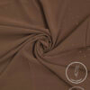 Lightweight, non-slip brown fabric with subtle gold specks for elegant fashion design.