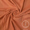 Lightweight, non-slip peach-colored fabric for clothing or crafts.