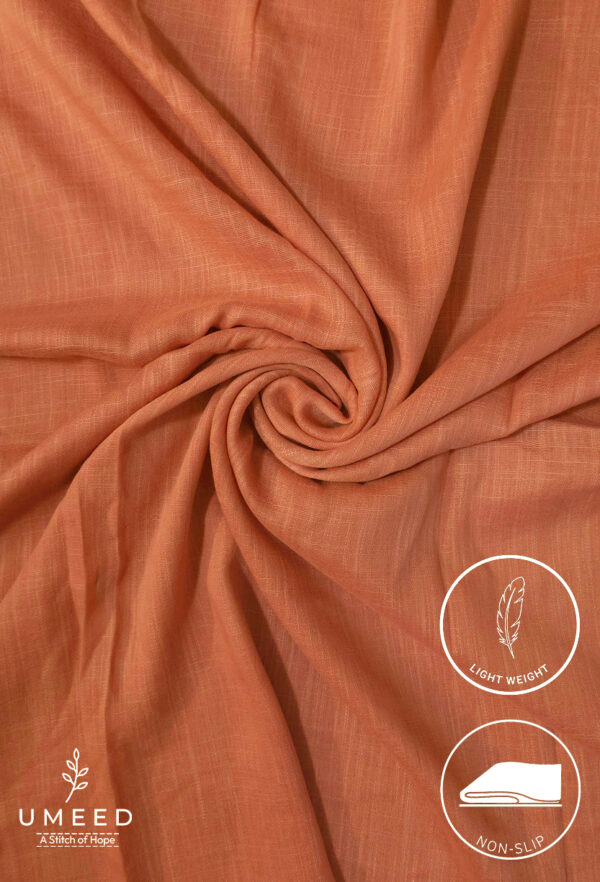 Lightweight, non-slip peach-colored fabric for clothing or crafts.