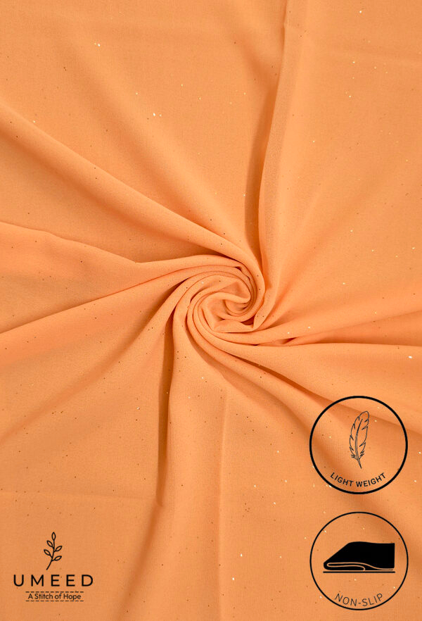 Peach-colored fabric with subtle glitter and light weight label from Umeed Designs.