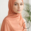 Beautiful woman wearing a peach hijab with subtle sparkle details.