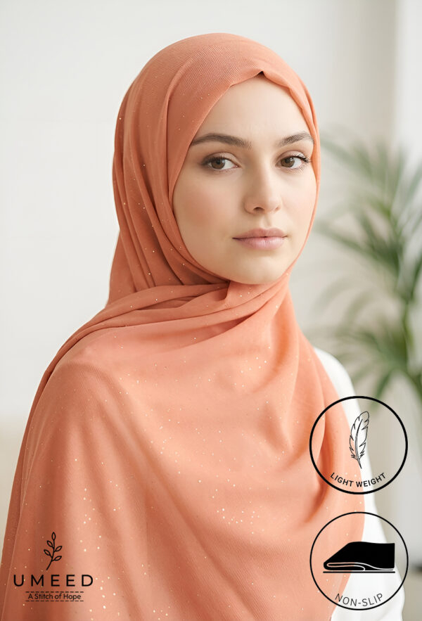 Beautiful woman wearing a peach hijab with subtle sparkle details.