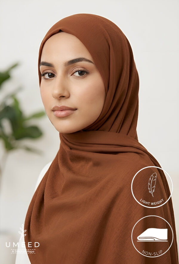 Elegant woman wearing a brown hijab, light makeup, and confident expression.
