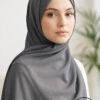Elegant woman wearing a dark gray hijab with subtle gold accents.