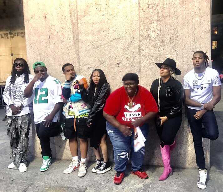 People street fashion group posing outdoors in casual stylish clothing.