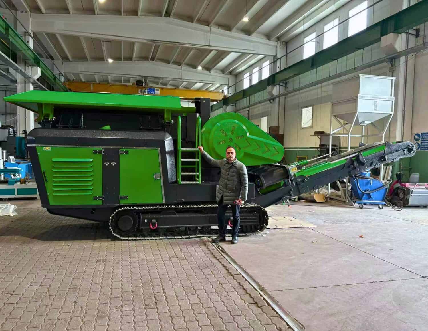 Customer standing beside an UPSEN 704 jaw crusher in a workshop.