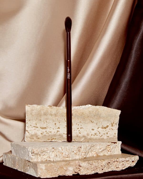 Pensulă de machiaj și bucăți de marmură pentru decor.