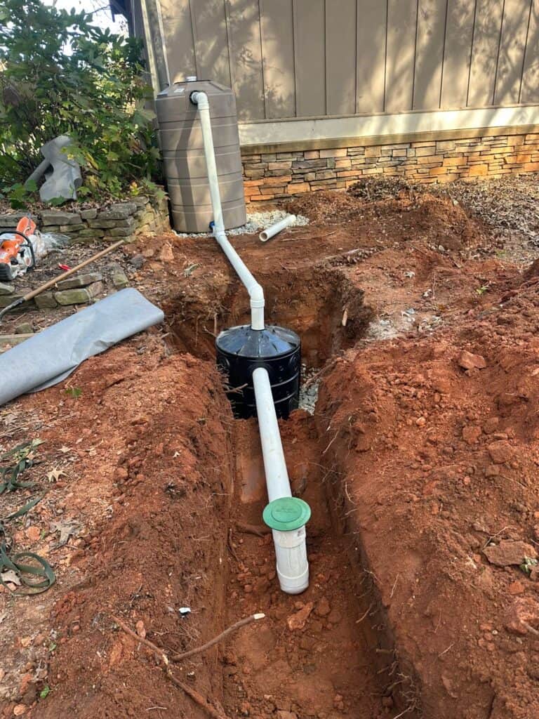 Dry well excavation showing the Flo-Well chamber with PVC pipe connection from the cistern and a green pop-up overflow emitter at the UGA GSI demo site
