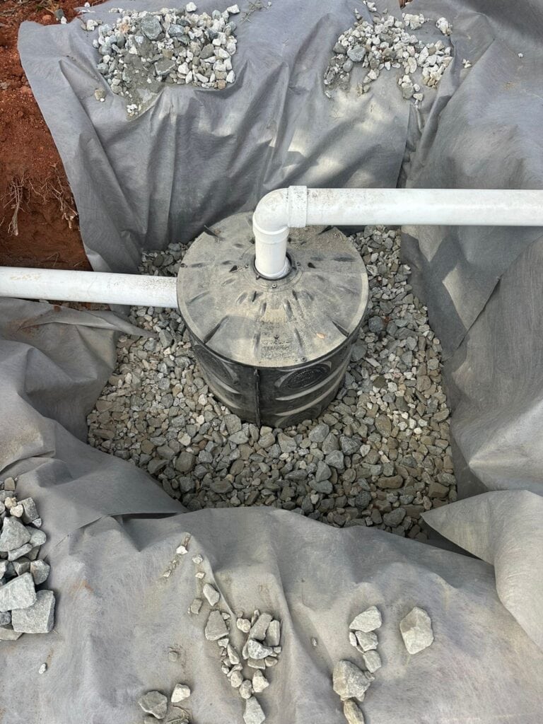 Dry well Flo-Well chamber surrounded by number 57 crushed stone within an erosion control filter fabric liner at the UGA GSI demo site