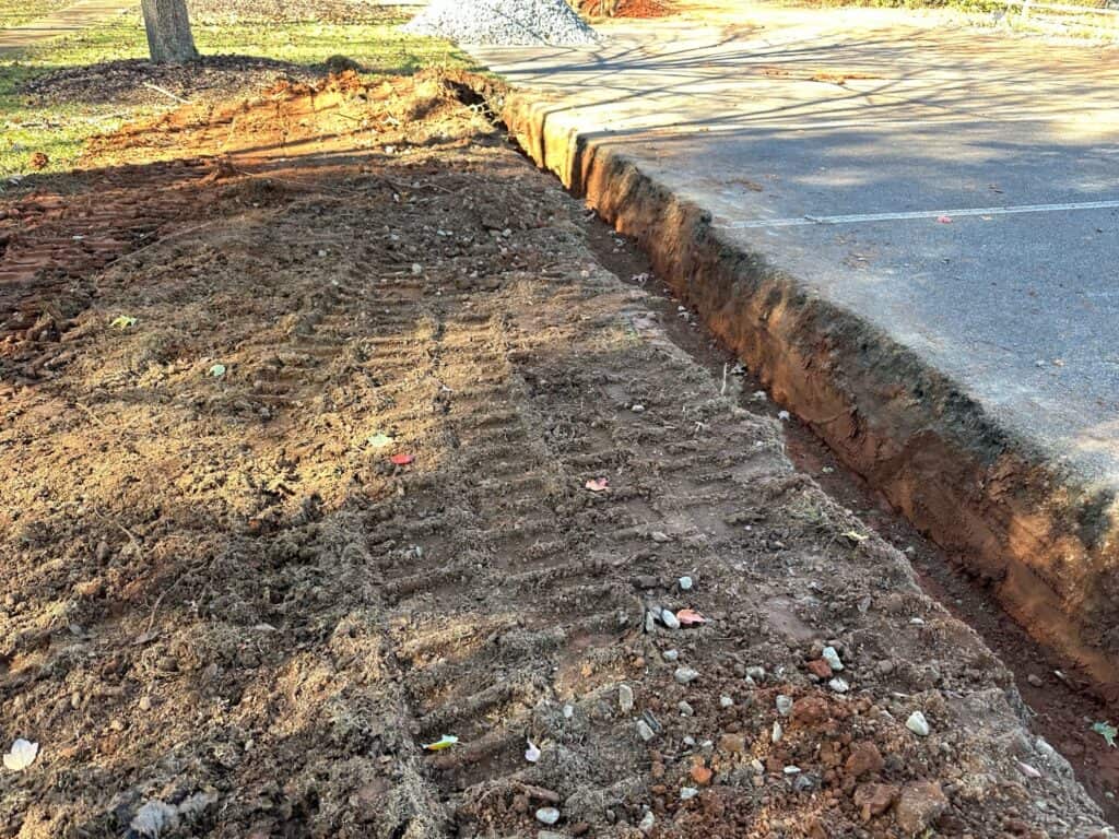 Excavated 18-inch-deep trench along a parking area curb for the French drain installation at the UGA GSI demo site