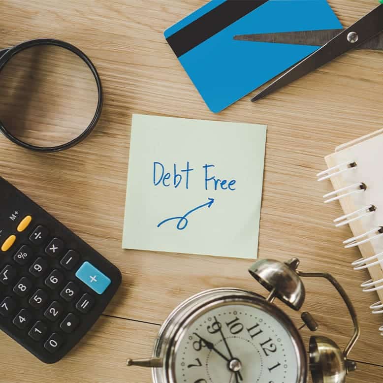 the words debt free written on a note on a desk